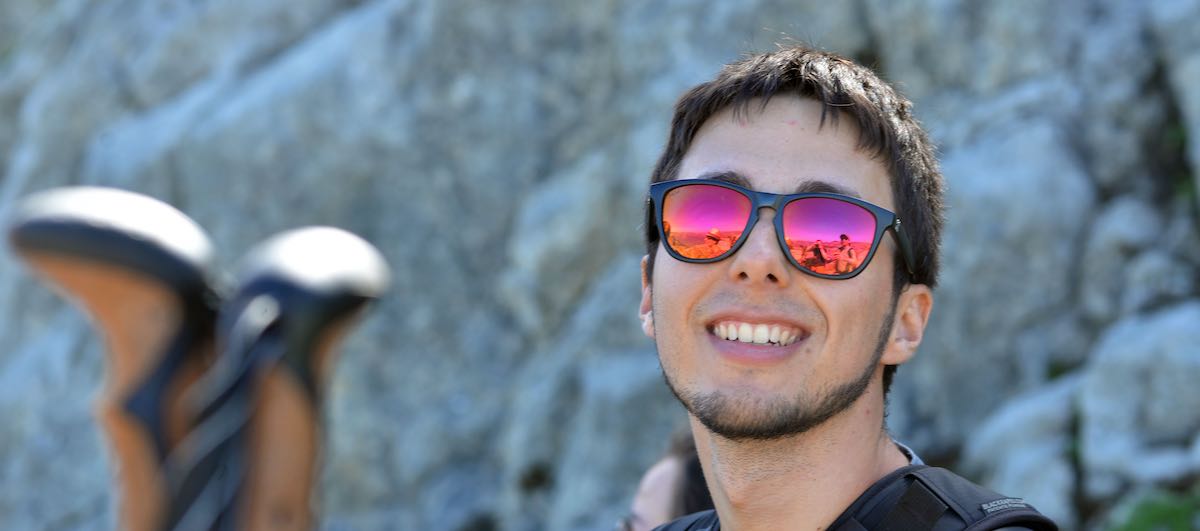 Photo portrait de David avec des lunettes de soleil, en montagne