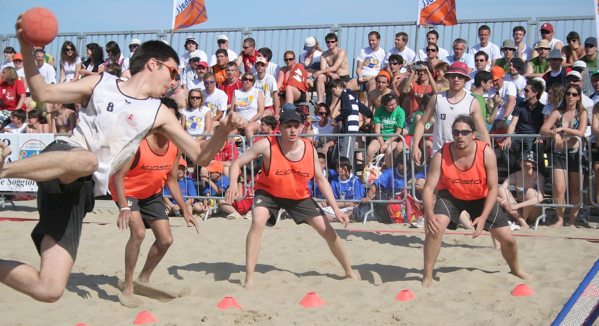 David about to shoot, playing on sand with the Swiss national team in front of a crowded audience
